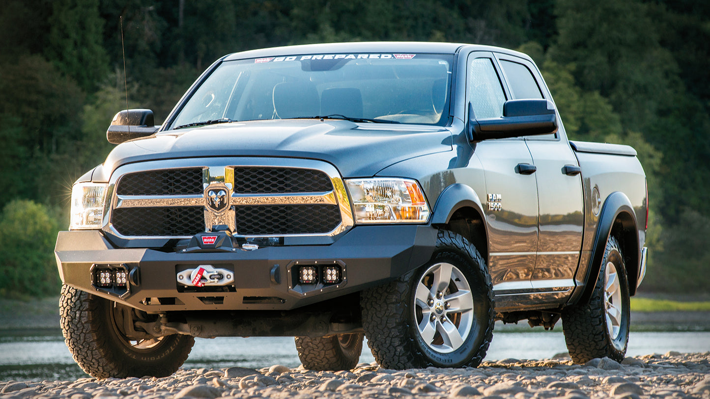WARN Ascent Front Bumper for 2011-2018 Ram 2500/3500 shown on an off-road vehicle near a river