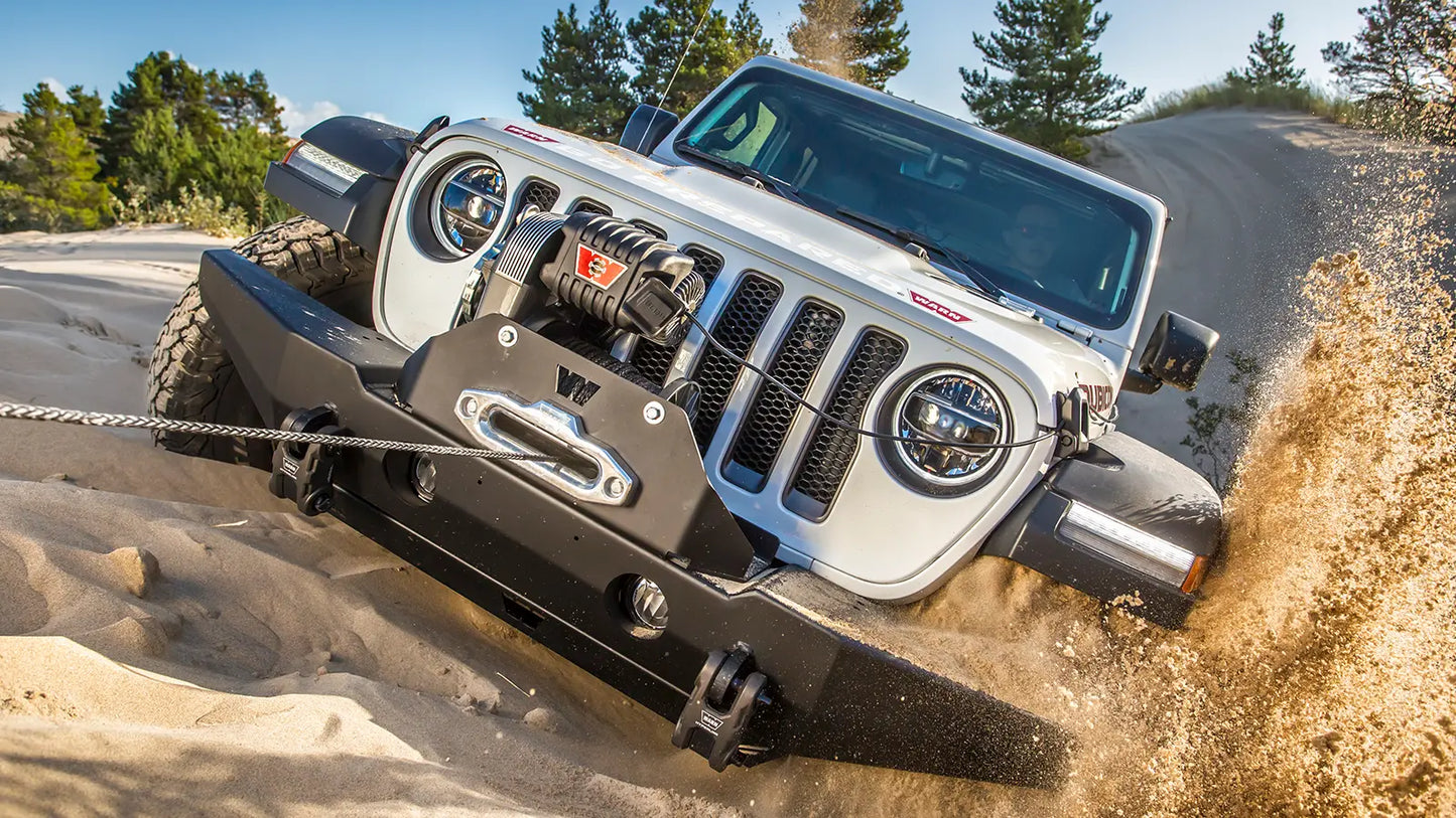 WARN M8274-S 10,000 lb truck, Jeep, and SUV winch shown in sandy off-road terrain
