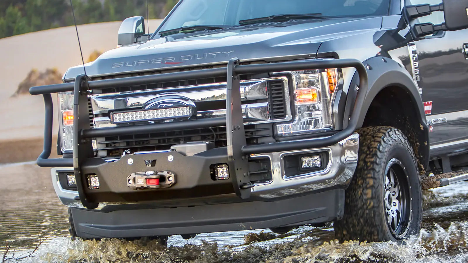 WARN Trans4mer Gen III Bracket Kit for 2017-2026 Ford Super Duty winch mount kit shown on an off-road vehicle crossing water