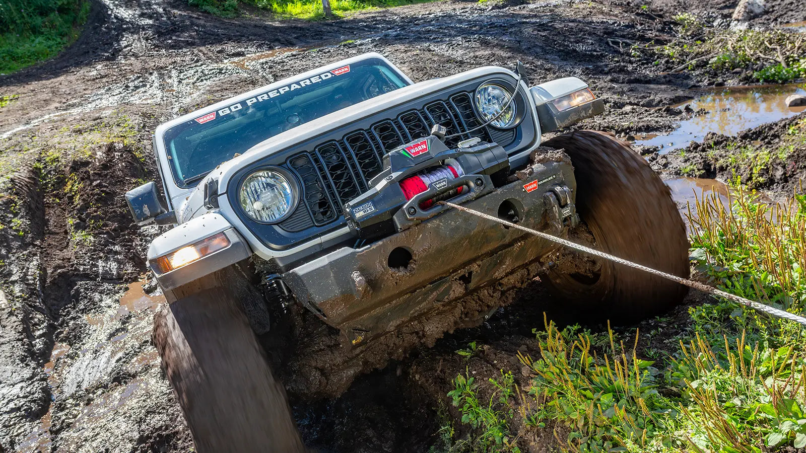 WARN ZEON XP 12-S 12,000 lb truck, Jeep, and SUV winch shown in muddy off-road terrain