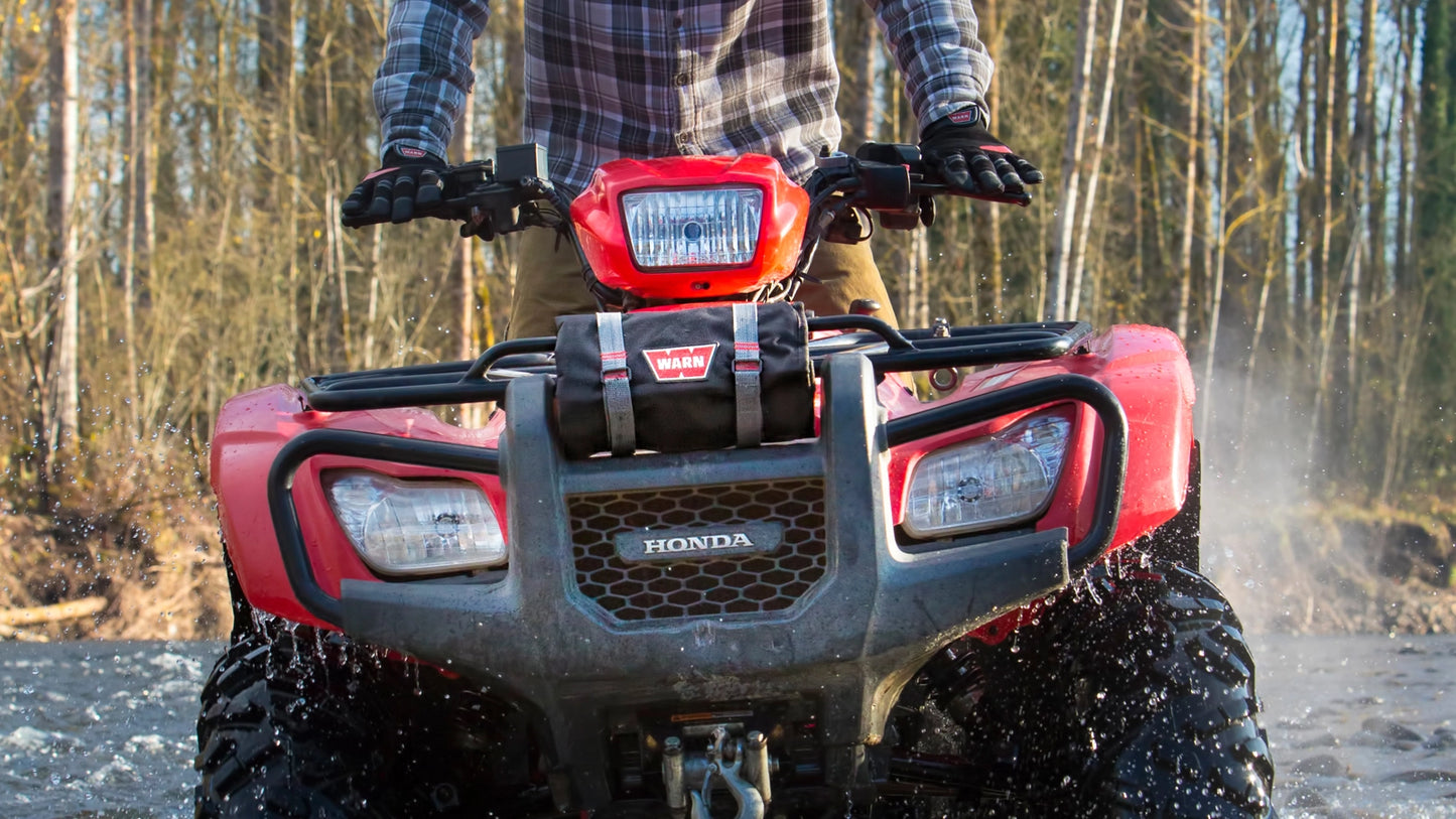 WARN Tool Roll Recovery Kit winch rigging kit shown on a wooded trail