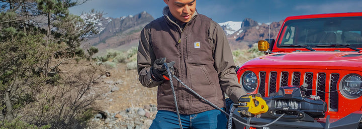 WARN step-by-step process replacing steel winch cable with synthetic rope, showing rope removal, drum attachment, and respooling procedure for off-road winch conversion